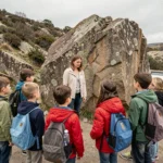 Groupe d'enfants en sortie scolaire avec leur enseignante observant des formations rocheuses en plein air